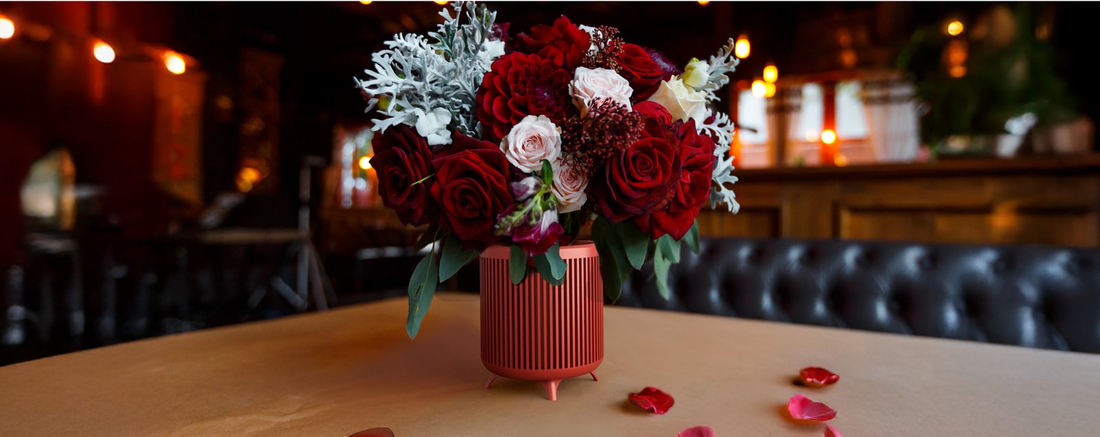 A Ray Decore vase holding red roses on a table in a warm interior