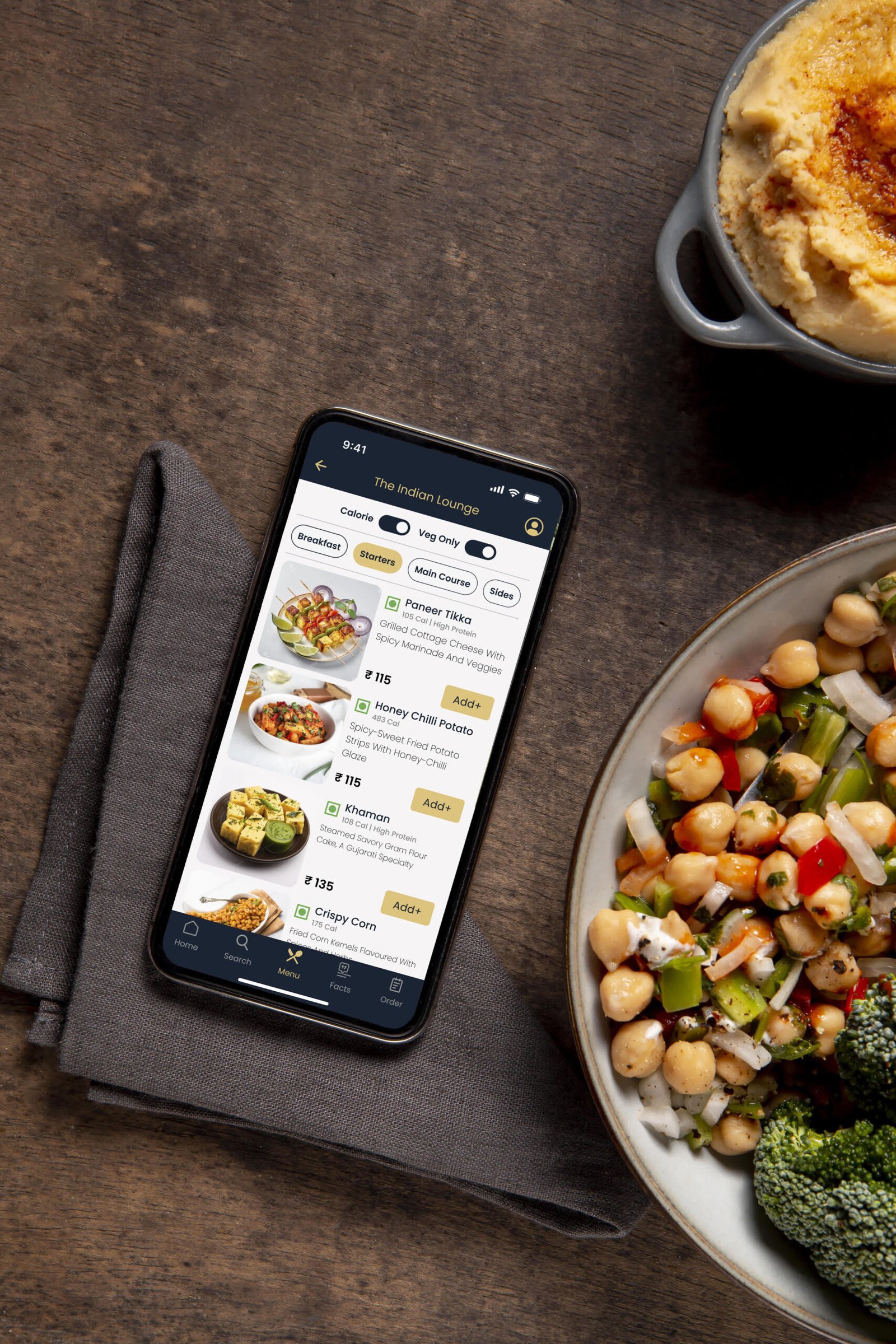 The Aroma menu open on a phone next to bowls of Indian food, shot from above